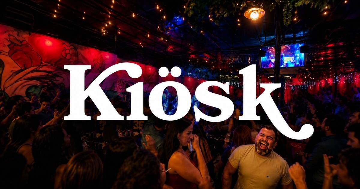 Ambiente do Kiosk em uma noite de música, com iluminação colorida e a marca da casa